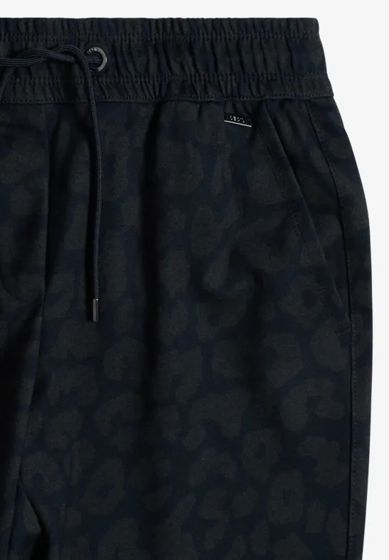 Nahaufnahme einer dunkelblauen Jogginghose mit elastischem Bund und dezentem Tiermuster.