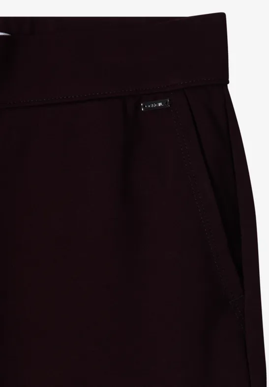 Gros plan sur un pantalon de jogging bordeaux avec poche latérale et petit label