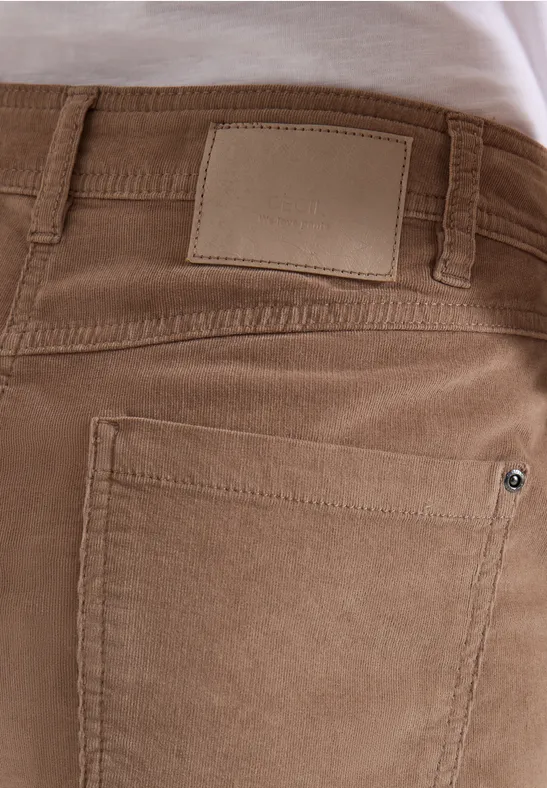 Nahaufnahme einer Person von hinten in hellbrauner Cordhose mit hinterer Tasche und Lederetikett am Bund.