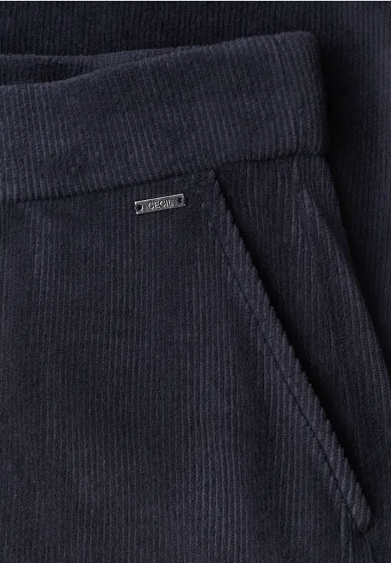 Dunkelblaue Cordhose mit eingesteckter Fronttasche und kleinem Metall-Label