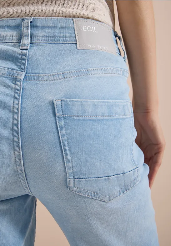 Rückenansicht einer Person in hellblauen Jeans mit sichtbarer Gesäßtasche.