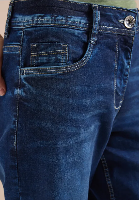 Detailaufnahme einer dunkelblauen Jeans mit Tasche und kontrastierenden Nähten.