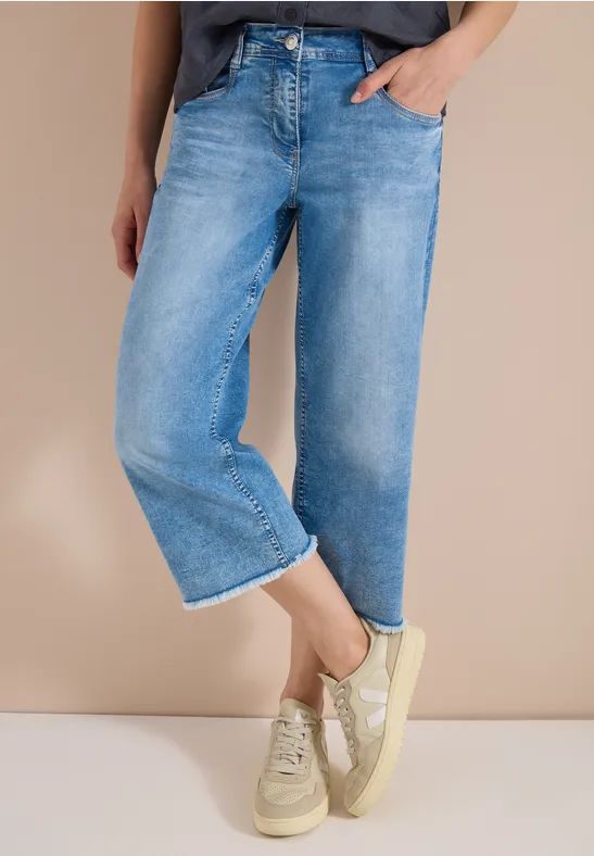 Lichtgewassen, wijde enkeljeans gecombineerd met lichte sneakers.