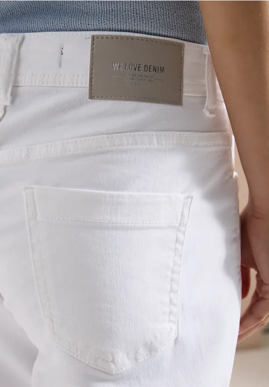 Nahaufnahme einer weißen Denim-Jeansrückseite mit Gesäßtasche und Markenlabel am Bund.