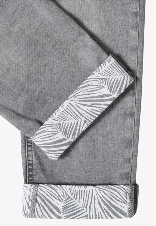 Grijze spijkerbroek met omgeslagen boord en wit bladprint aan de binnenkant.