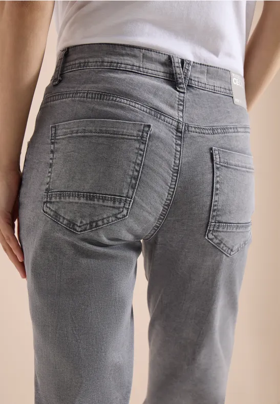 Achteraanzicht van een persoon in grijze jeans en wit T-shirt