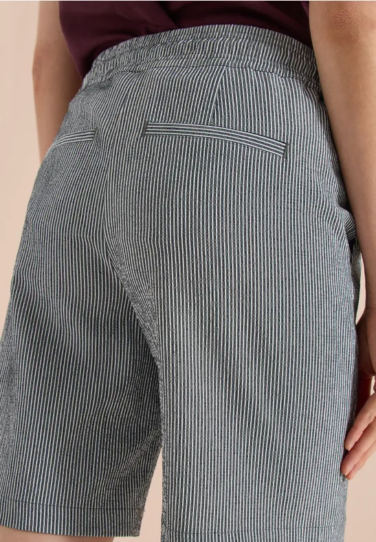 Rückenansicht einer Person, die eng anliegende, grau-weiß gestreifte Shorts trägt.