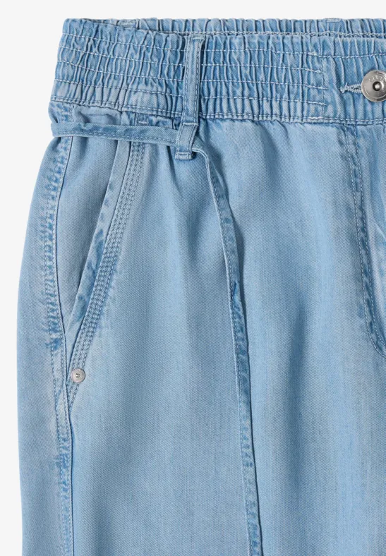 Lichtblauwe denim broek met elastische taille, trekkoord en steekzakken.