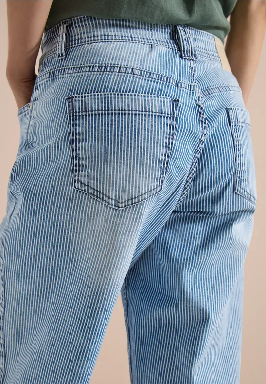 Nahaufnahme einer Person, die eine hellblaue gestreifte Jeans von hinten trägt.
