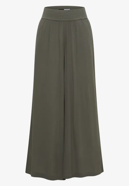 Locker geschnittene, weite Hose aus dunkelgrünem, fließendem Stoff mit breitem, elastischem Bund.