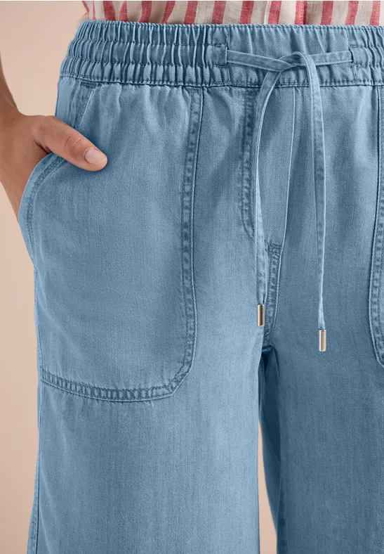 Hellblaue, bequeme Hose mit Gummibund, Tunnelzug und aufgesetzten Taschen.