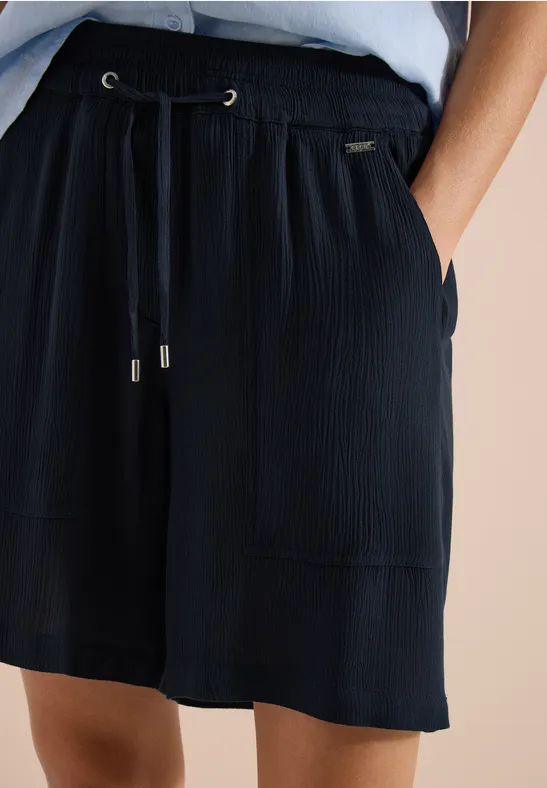 Losse zwarte plissé-short met elastische taille, trekkoord en opgestikte zakken.