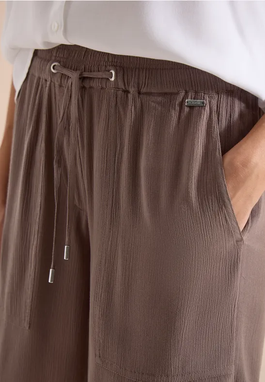 Ribgebreide bruine vrijetijdsbroek met aantrekkoord en zakken, gecombineerd met een wit shirt