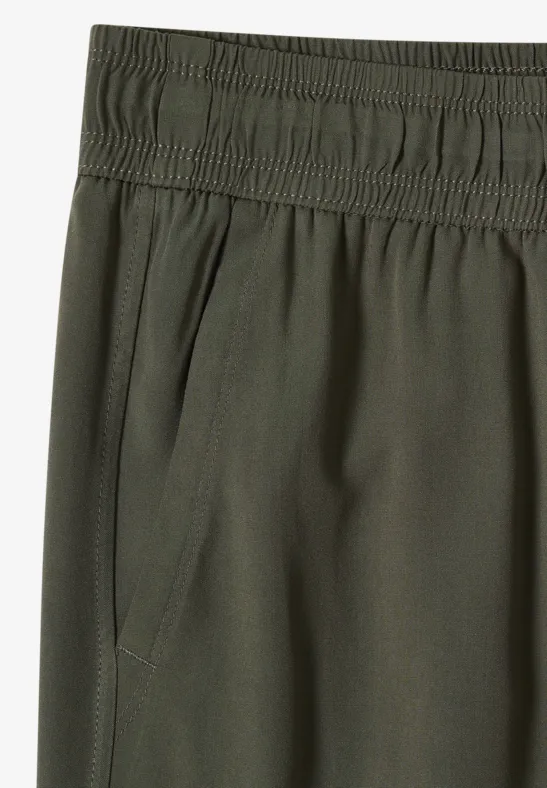 Pantalon vert olive à taille élastique avec poche latérale.