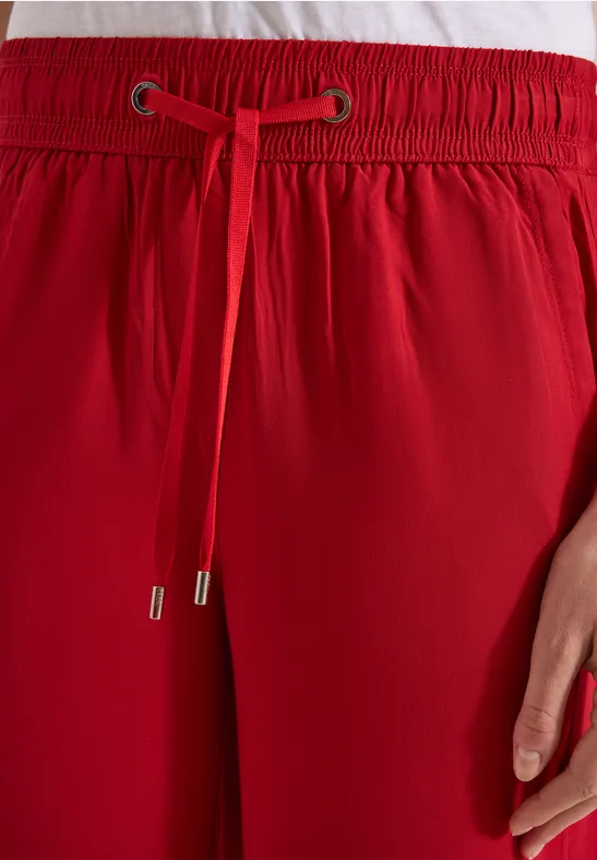 Rode broek met elastische taille en aantrekkoord, detailweergave.