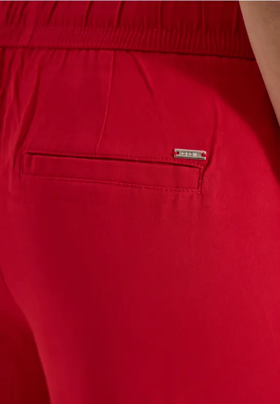Achterzijde van rode short met achterzak en merklabel