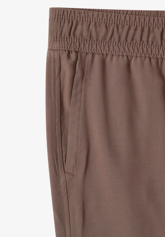 Bruine sportbroek met elastische taille en zijzak.