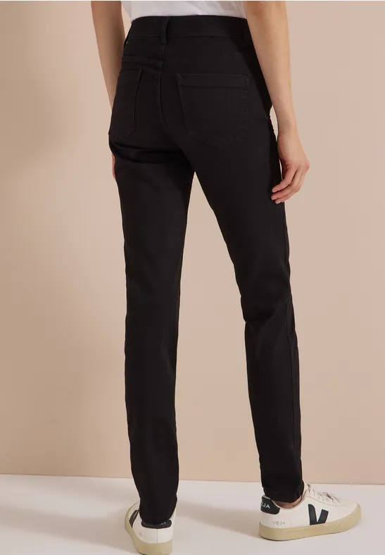 Pantalon noir pour femme, coupe droite taille haute, vu de dos et assorti à des baskets blanches.