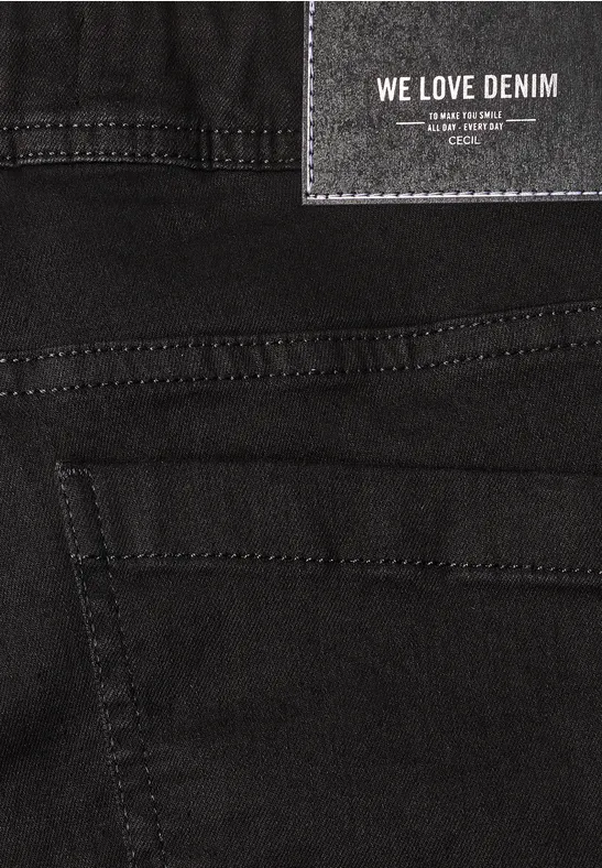 Nahaufnahme einer schwarzen Denim-Jeans mit Etikett 'WE LOVE DENIM' und sichtbaren Nähten