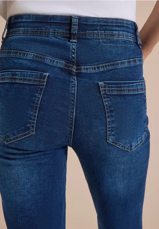 Nahaufnahme einer Person in eng anliegenden blauen Jeans von hinten.