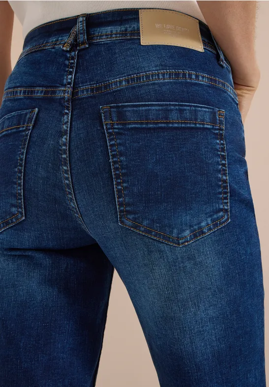 Rückenansicht einer Person in dunklen Jeans mit ausgeprägten Gesäßtaschen.