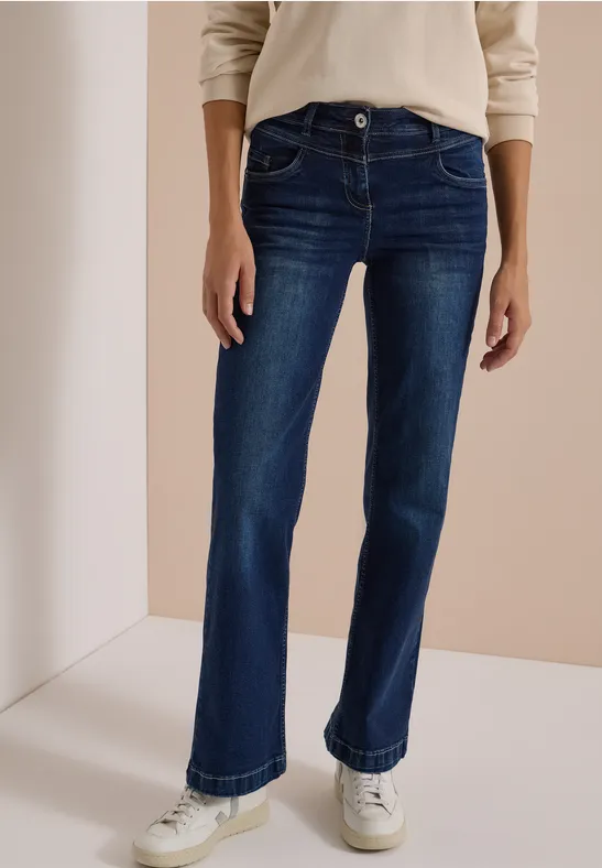 Dunkelblaue, gerade geschnittene Jeans mit weißen Sneakern