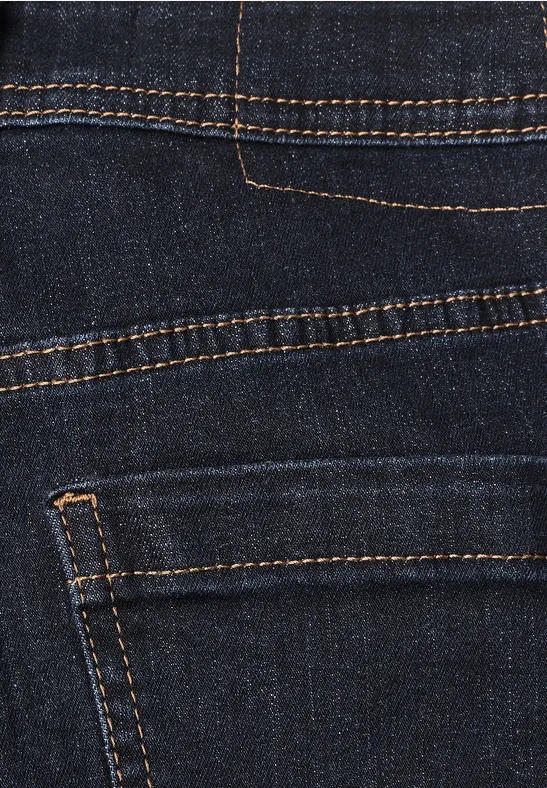 Nahaufnahme einer dunklen Jeanshose mit orangener Naht und rückseitiger Tasche.