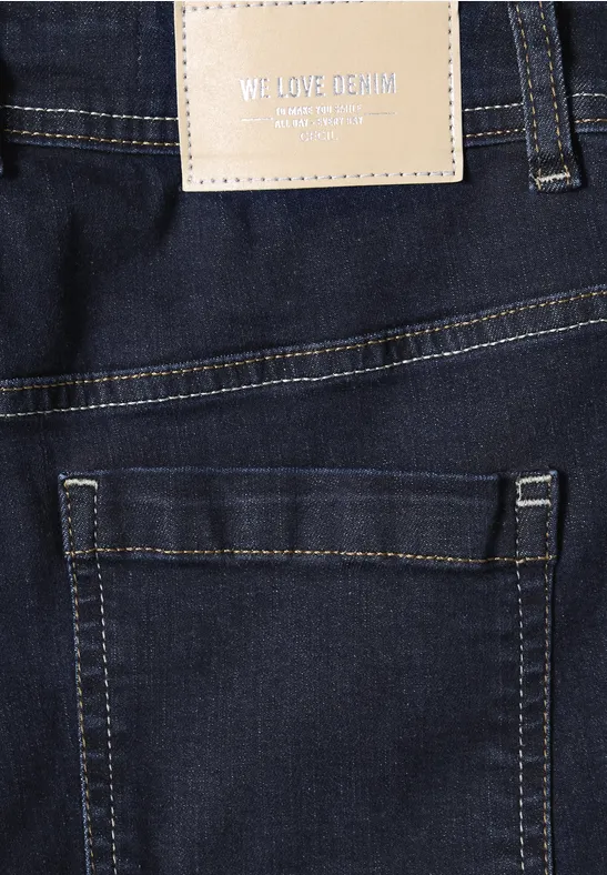 Rückansicht einer dunklen Jeans mit Gesäßtasche und Lederetikett 'WE LOVE DENIM'.
