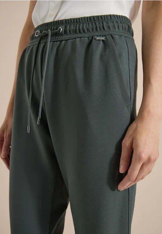 Donkergroene joggingbroek met trekkoord, elastische taille en zijzakken.