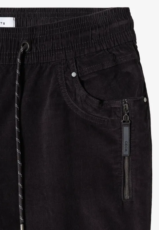 Schwarze Cord-Jogginghose mit Gummibund, Tunnelzug und seitlicher Reißverschlusstasche.