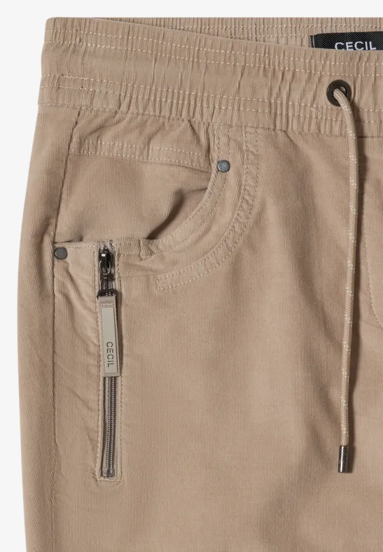 Beige Cordhose mit Kordelzugbund, Reißverschlusstasche und Ziernähten.