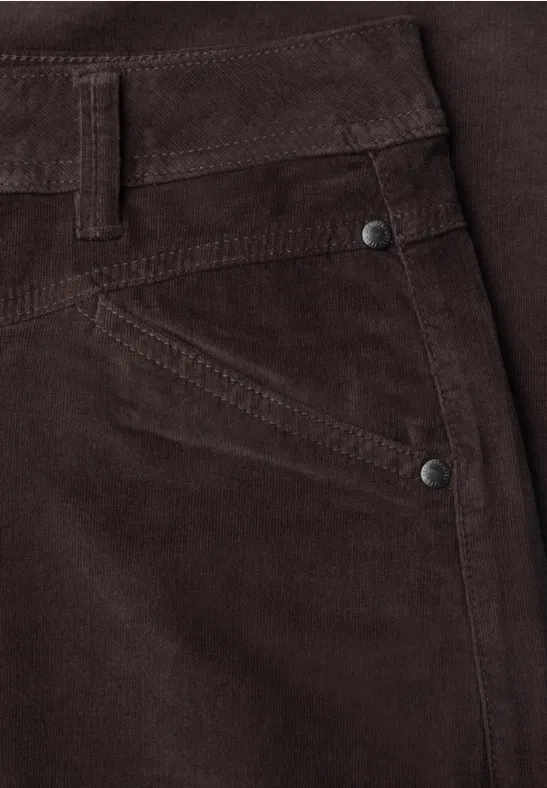 Nahaufnahme einer braunen Cordhose mit Tasche und Metallnieten.