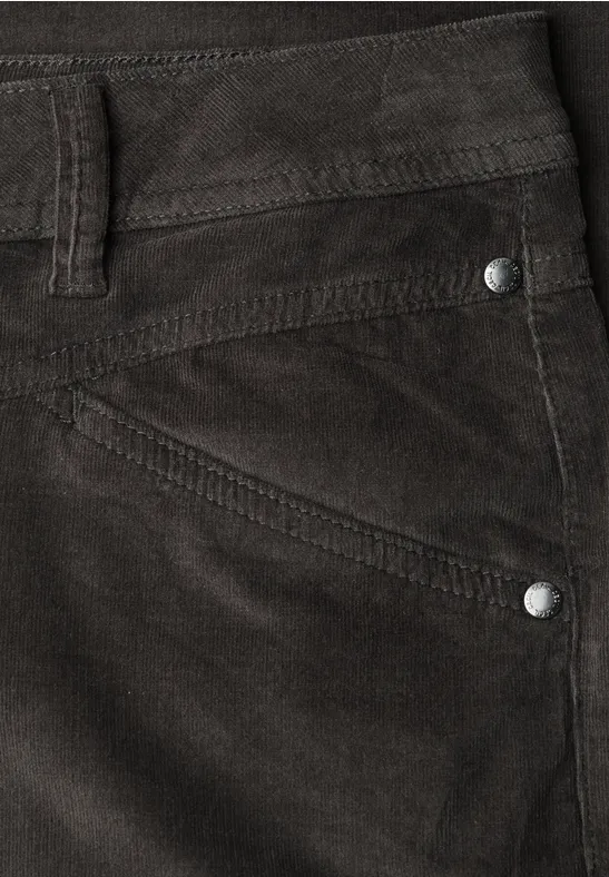 Nahaufnahme einer dunkelbraunen Cordhose mit Tasche, Gürtelschlaufe und silbernen Nieten.