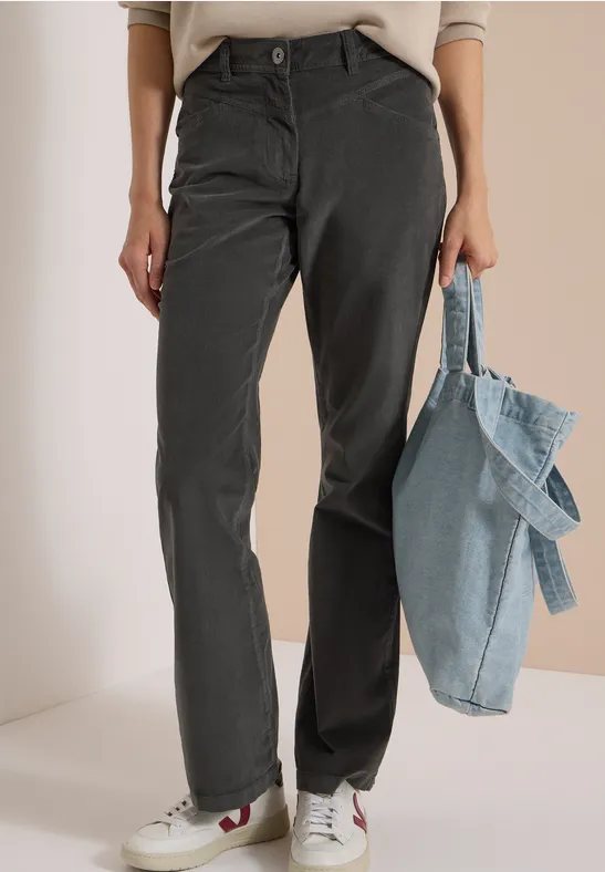 Pantalon droit gris, baskets blanches à détails rouges et sac fourre-tout en denim bleu clair.