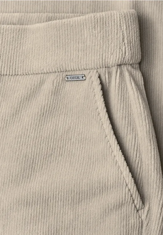 Pantalon en velours côtelé beige avec taille élastique et poche latérale.