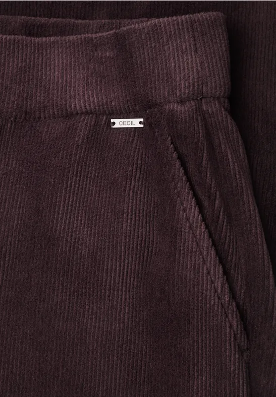 Nahaufnahme einer dunkelvioletten Cordhose mit Seitentasche und Gürtelbund.