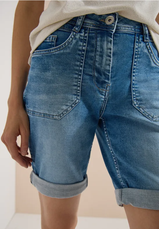 Detailaufnahme von blauen Jeans-Shorts mit umgeschlagenem Saum an Taille und Oberschenkeln.