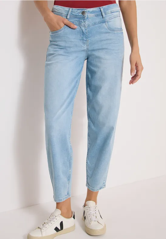 Eine Person trägt hellblaue, hoch taillierte Jeans mit geradem Bein und weiße Sneaker.