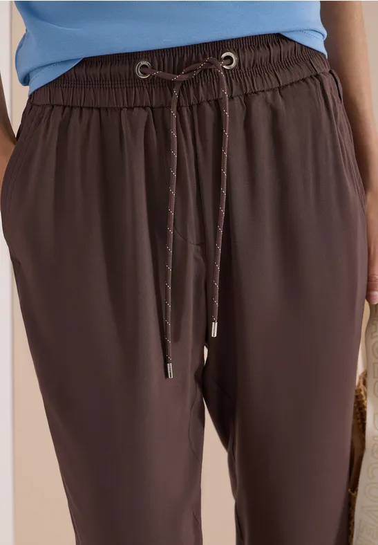 Schwarze, lockere Hose mit elastischem Bund und Kordelzug.