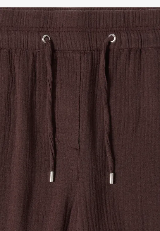 Braune Hose aus Crinkle-Baumwollstoff mit elastischem Bund und Tunnelzug.
