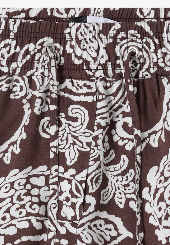 Brauner Stoff mit weißem, verspieltem Blumenmuster und elastischem Bund