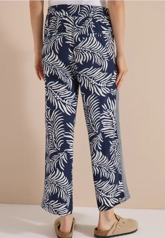 Achteraanzicht van een losse marineblauwe broek met wit tropisch bladpatroon.