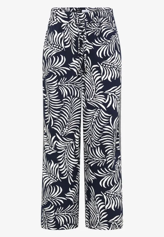 Wijde broek met donkere achtergrond en wit tropisch bladpatroon.