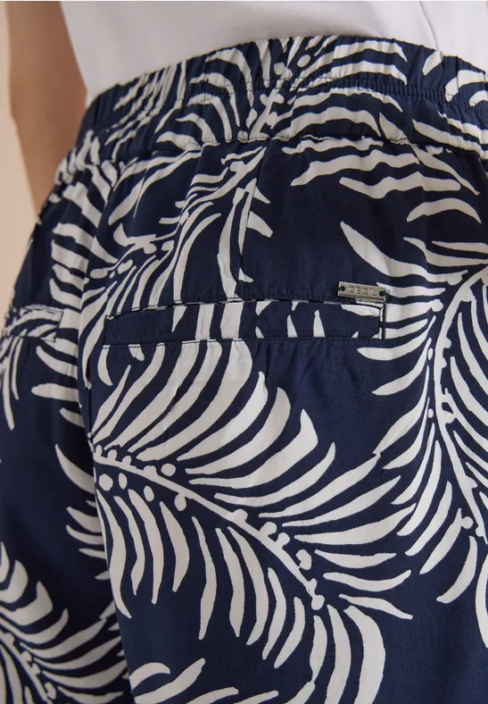 Donkerblauwe broek met wit palmbladpatroon, elastische tailleband en achterzak.