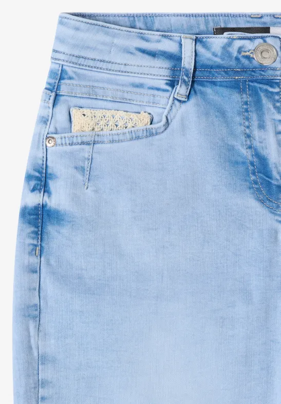 Helles hellblaue Damenjeans mit dekorativer Häkelspitze im Münzfach am vorderen Hosentaschenbereich.