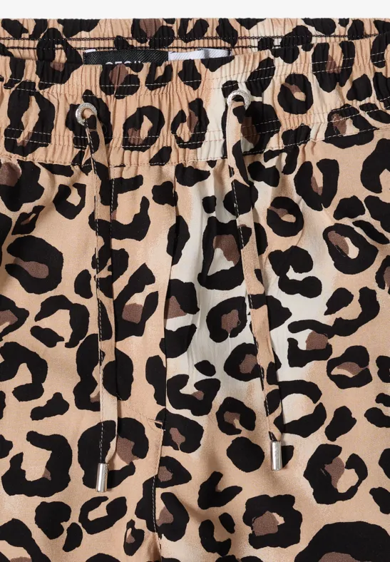 Close-up van beige stof met zwarte luipaardprint en trekkoord.