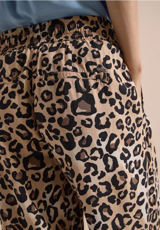 Damesbroek in beige met zwarte luipaardprint, elastische tailleband en achterzak.