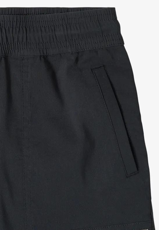 Zwarte trainingsbroek met zijzak en elastische tailleband.