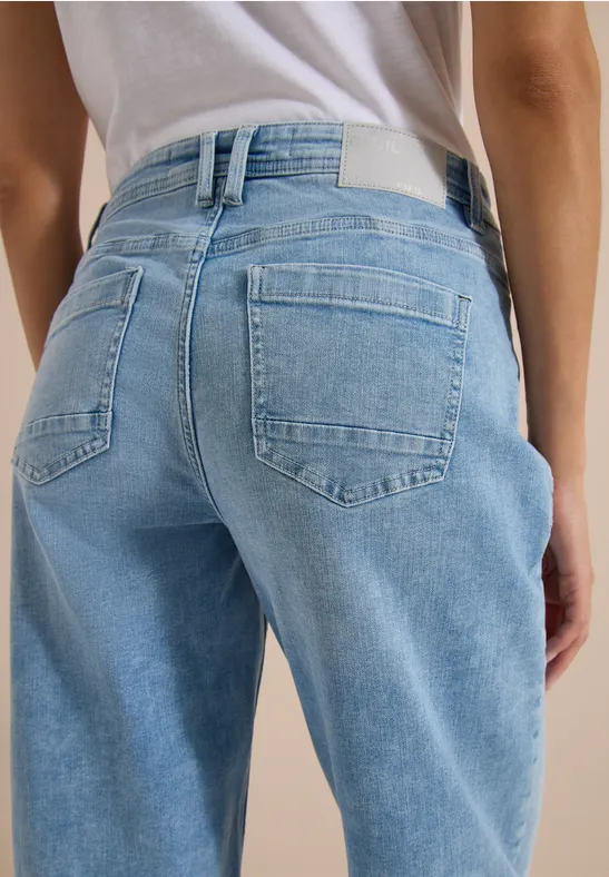 Rückansicht einer Person in hellblauen Jeans.