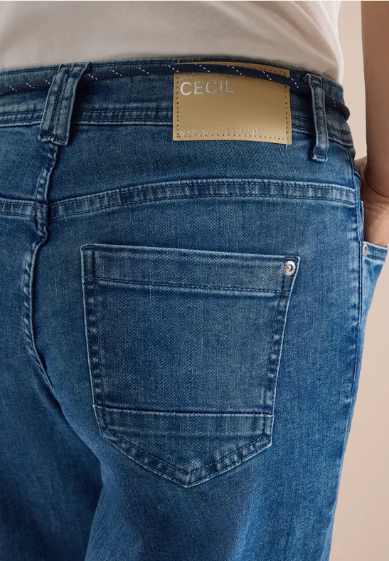 Rückansicht einer Person in blauen Jeans mit CECIL-Label über der Gesäßtasche.